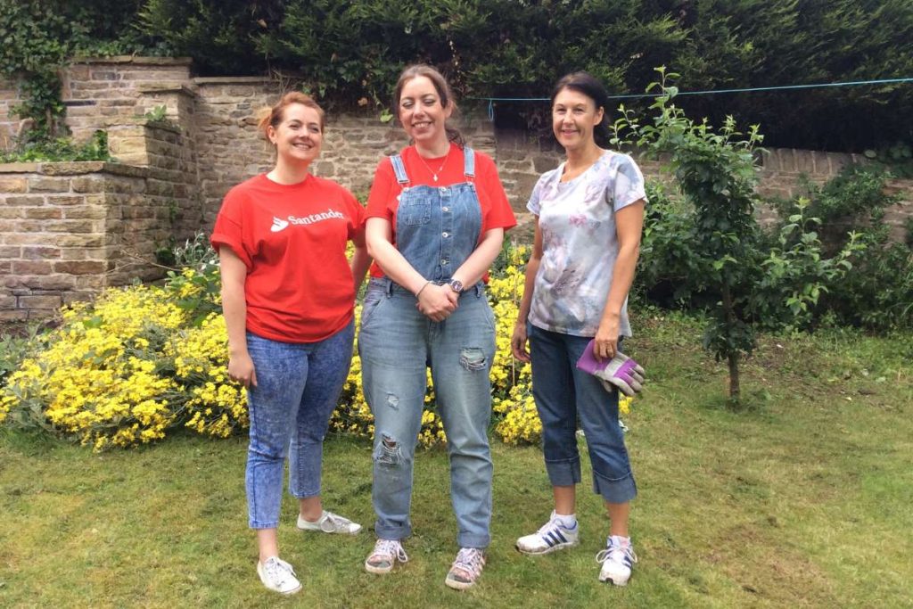 3 female volunteers standing in a garden